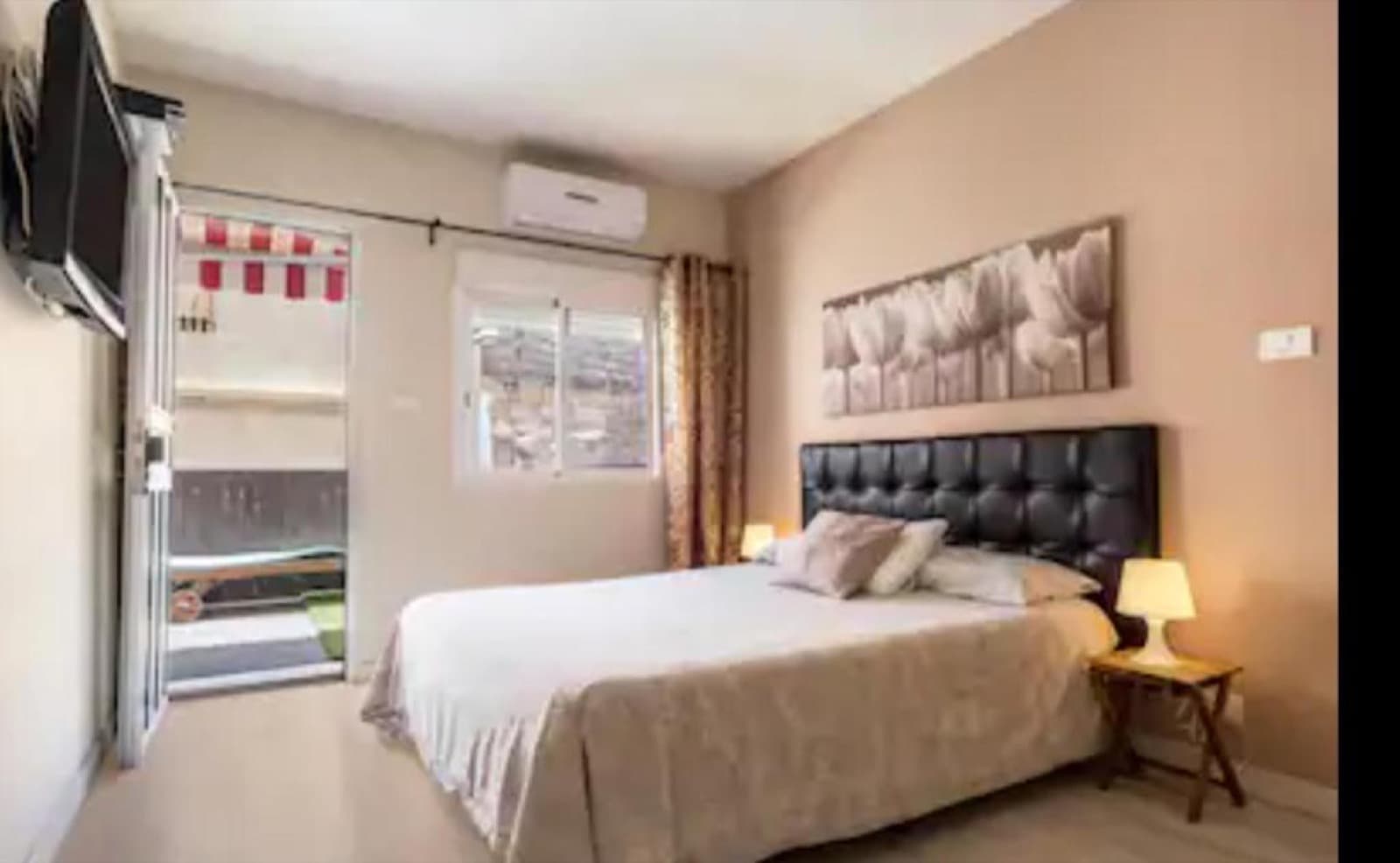 Schlafzimmer mit Doppelbett und Zugang zum Balkon